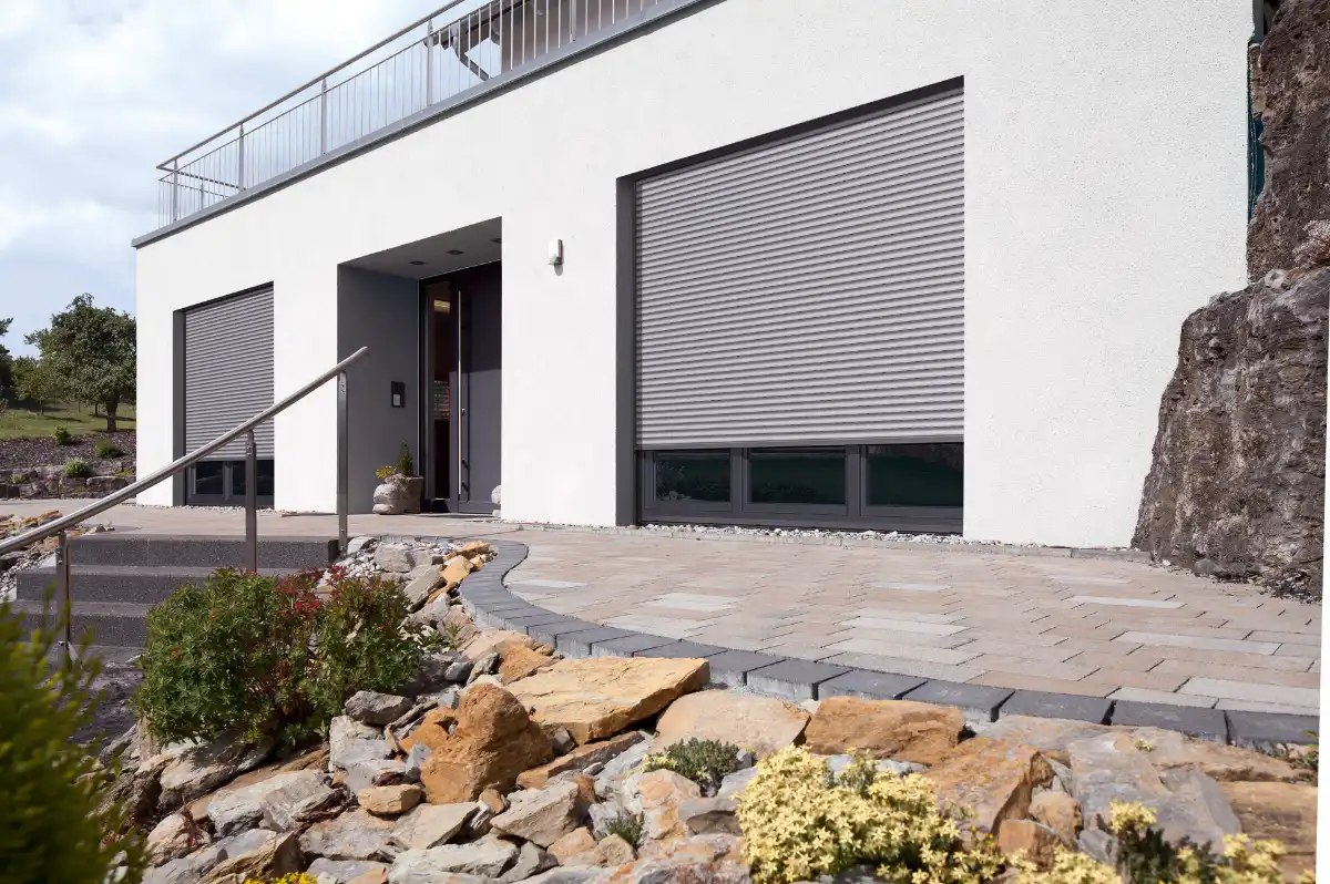 Modernes Einfamilienhaus mit geschlossenen Rollläden und gepflegtem Vorgarten